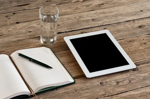 Tableta con una pantalla en blanco en una mesa de madera —  Fotos de Stock