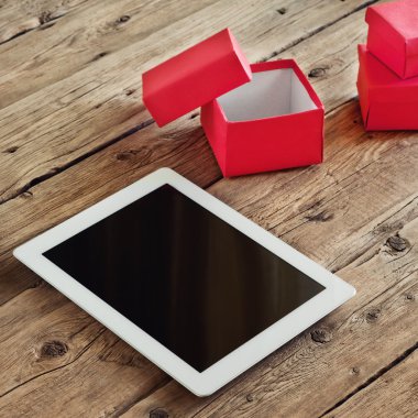 Tablet computer with gifts and a cup of coffee