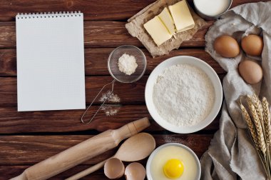 Kitchen notebook with blank pages with ingredients for baking