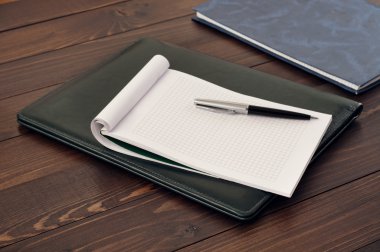 Boş not defteri ve kalem deri klasörde