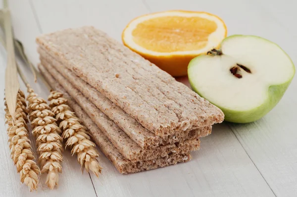 Dry diet crisp breads with ears of wheat and fruit — Stock Photo, Image