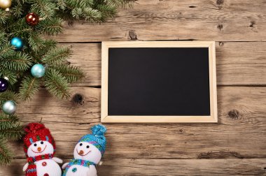 Branch of a Christmas tree with board for chalk