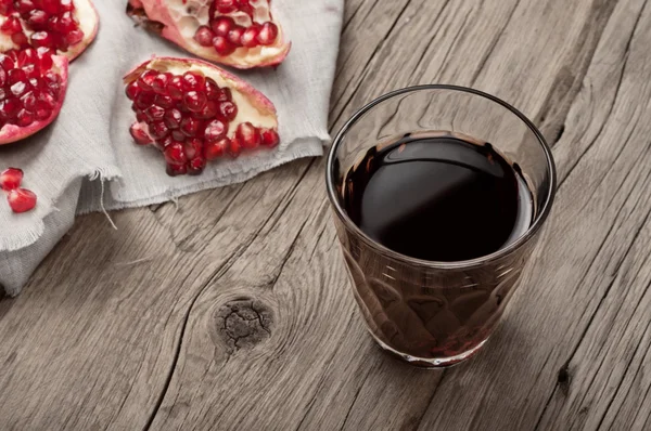 Copo de suco de romã com fatias de romã — Fotografia de Stock