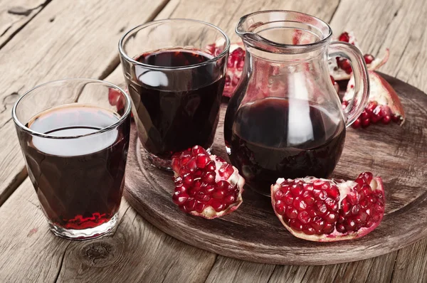 Copo de suco de romã vermelha com fatias de romã — Fotografia de Stock