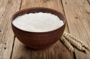 Flour in a bowl on wooden table