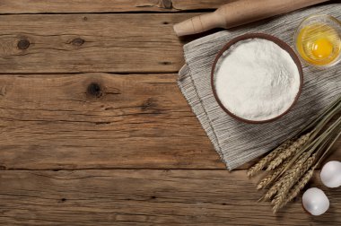 Flour in a bowl with ingredients for preparing baked products