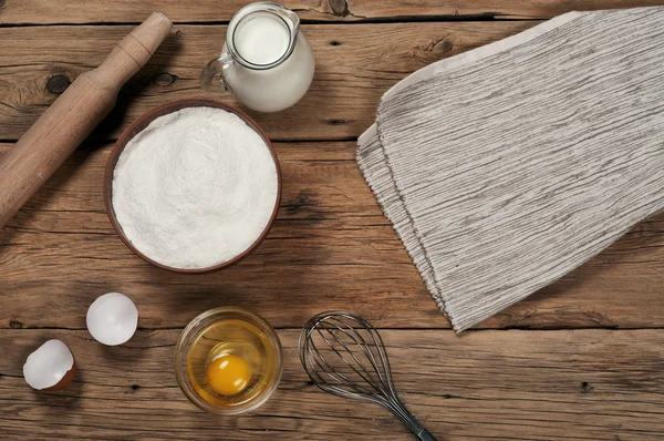 Flour in a bowl with ingredients for preparing baked products — Stock Photo, Image