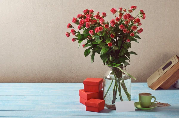 Bouquet di rose, regali, tazza di caffè e carta — Foto Stock