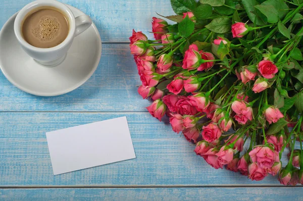 Букет розовых роз, чашка кофе и поздравительная открытка — стоковое фото