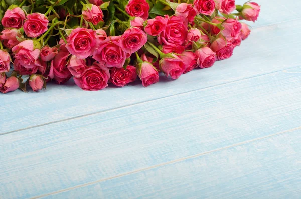 Bouquet de roses roses sur une surface bleue — Photo