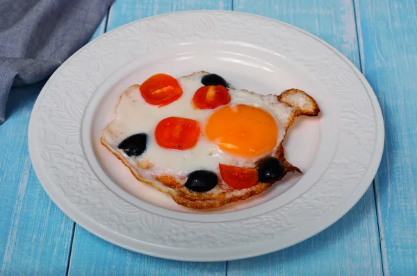 Жареные яйца с помидорами и оливками черри — стоковое фото