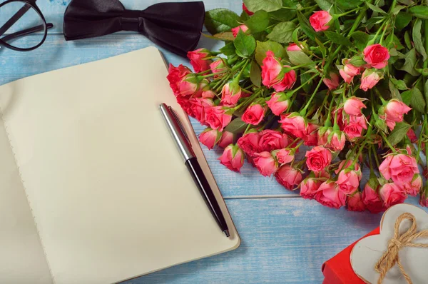 Букет роз с блокнотом и подарком — стоковое фото