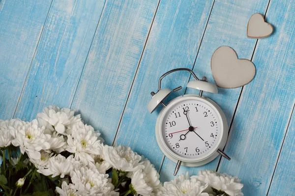 Ramo de flores con despertador y un corazón de madera — Foto de Stock