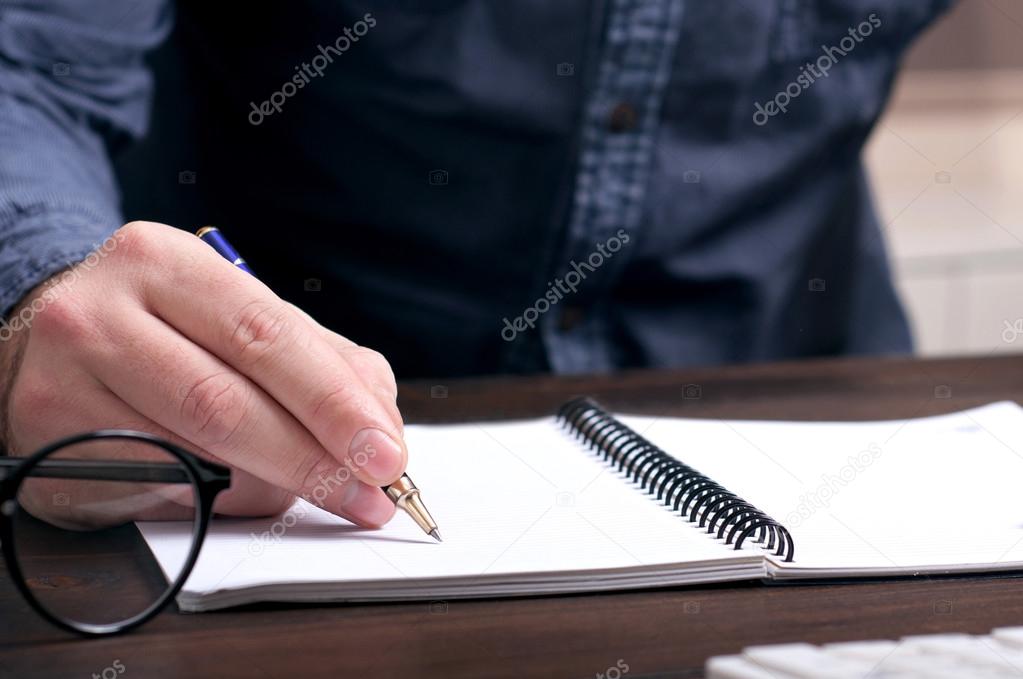 businessman makes a note at notebook