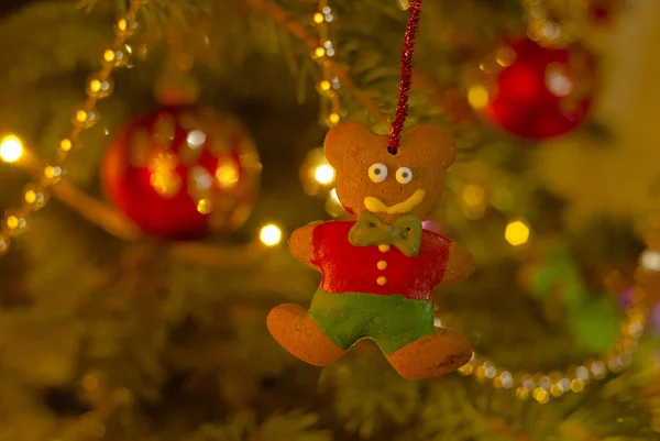 Плюшевый мишка с пряниками висит на рождественской елке — стоковое фото