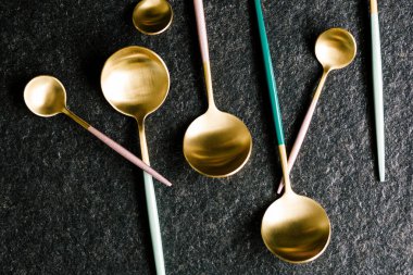 Siyah arka planda izole edilmiş şık ve renkli kaşıklar. Düz ve üst görünüm