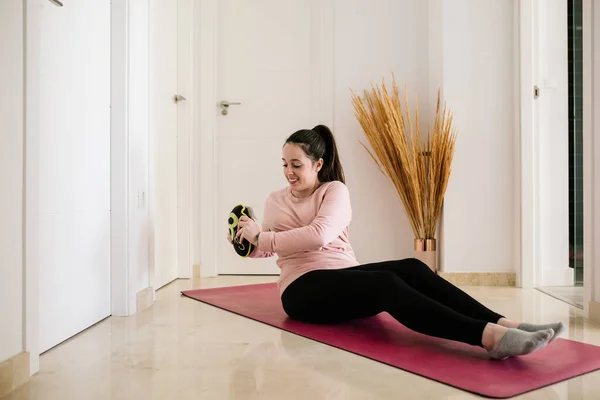white woman with brown hair doing her sport routine at home due to coronavirus pandemic