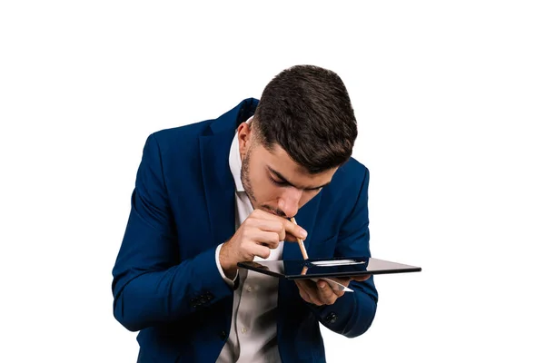 Beyaz arka planda izole edilmiş bir tablete kokain çeken genç bir iş adamının yakın çekimi. Ağır uyuşturucu bağımlısı