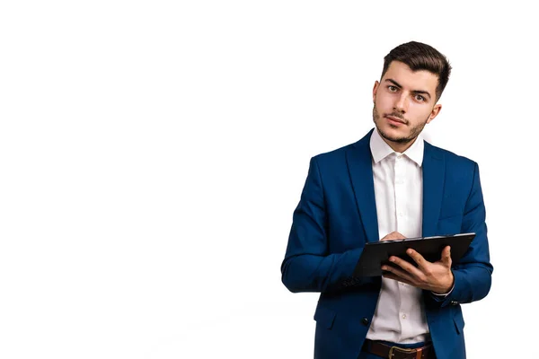 Beyaz iş adamı, esmer saçlı, beyaz arka planda izole edilmiş, tablet ekrana dokunurken kameraya bakıyor.