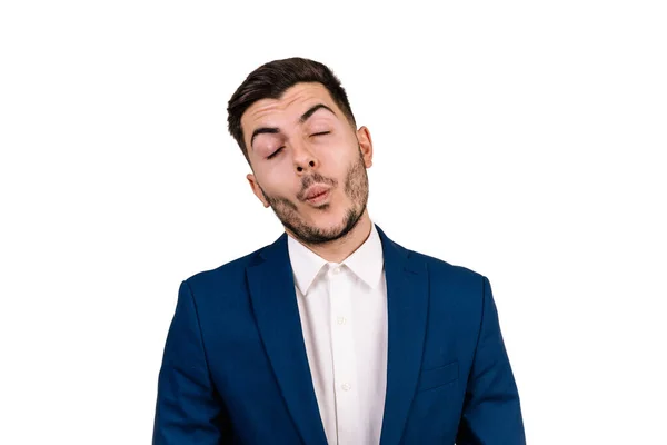 Siyah saçlı, takım elbiseli, yüzü beyaz arka planda soyutlanmış komik bir ifade takınan genç bir adam.