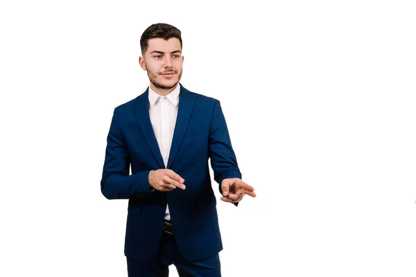 Genç adam beyaz bir arka planda iki eliyle işaret ederek izole edildi. Boşluğu Kopyala