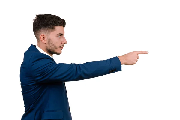 Zarif bir takım elbise giymiş genç bir işadamı beyaz bir arka planda izole edilmiş bir profili işaret ediyor.