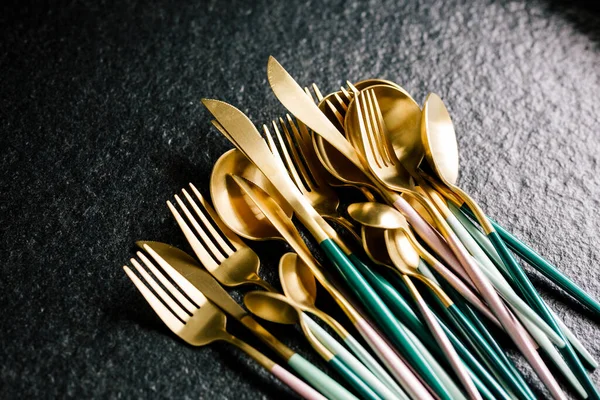 Siyah arka planda bir sürü zarif ve lüks çatal bıçak seti var. Uzayı kopyala Modern mutfak. Renkli çatal bıçak takımı
