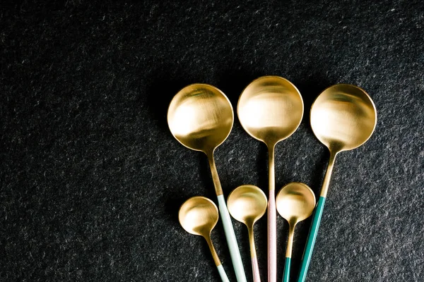 Siyah arka planda şık renkli kaşıklar. Modern mutfak. Restoran yemeği. Boşluğu Kopyala