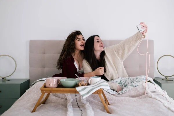 Beyaz kadınlar sabahları yatakta selfie çekiyorlar.