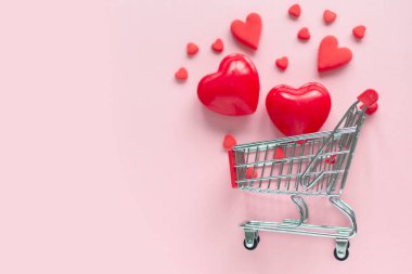 Sevgililer Günü çevrimiçi alışveriş. Pembe arka planda kalpleri olan bir alışveriş arabası. Romantik düğün alışverişleri, kadınlar günü, sevgililer için sevgililer günü hediyeleri. Mevsimlik tatil indirimi.