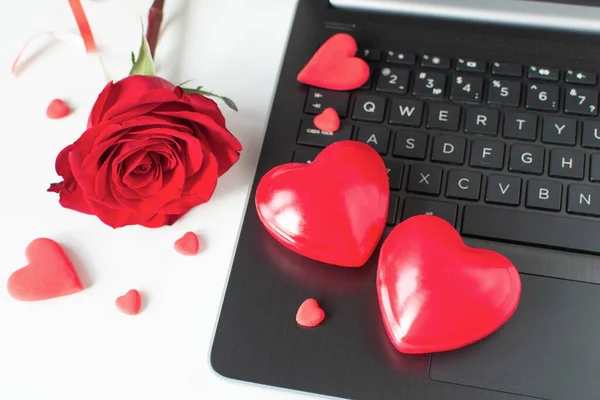 Valentine Day online Shopping. Online communication, virtual love. Laptop, red hearts, red rose. Seasonal Holiday sale. Romantic shopping wedding, women\'s day, buying gifts Valentine\'s Day for lovers.