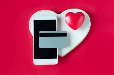 Sevgililer Günü çevrimiçi alışveriş. Kredi kartı, akıllı telefon, kırmızı kalp. Romantik düğün alışverişleri, kadınlar günü, sevgililer için sevgililer günü hediyeleri. Mevsimlik tatil indirimi.