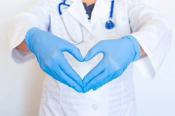 The doctor hands show folded hands into a heart. Medical gloves on hands to protect against infection. Invention of vaccines to treat viruses, diseases, bacteria, influenza. Concept care with love.