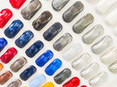 Bir araba rengi seçerken boya örnekleri. Yeni arabanın renklerini seçmek için arka plan paleti. Bayiliğin akrilik küçük araba figürleri çok farklı renklerde..