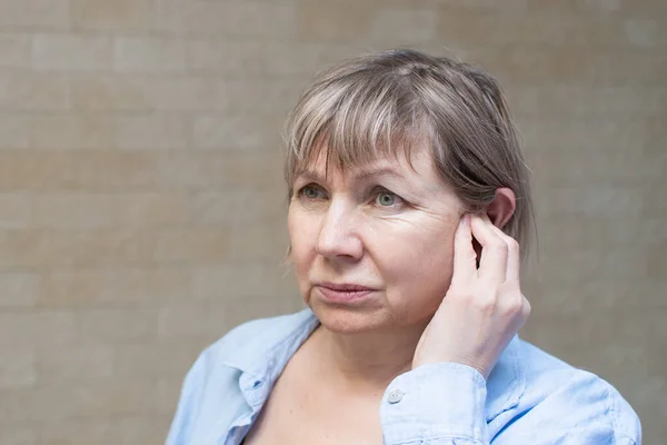 Senior woman ear pain. Otitis, Tinnitus. Ear infection Health care concept.