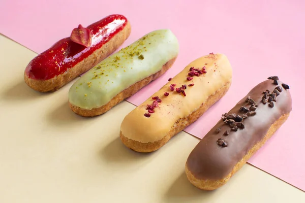 Eclairs chocolate, raspberry, pistachio and lemon close-up. Hello sweet mood. Concept baking, cookbook recipes, bakery banner, cafe advertisement. Background for vacation sales summer and holiday.Subject is blurred