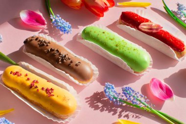 Lezzetli ekler, canlı laleler ve muscari çiçekleri. Sakin hayat. Merhaba yaz havası. Kavram pişirme, yemek kitabı tarifleri, pastane afişi, kafe reklamı. Yaz ve tatil satışları.