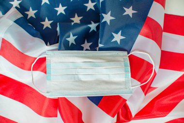 Arka planda Amerikan bayrağıyla tıbbi maske var. 4 Temmuz Bağımsızlık Günü ABD güvenliği. Anma günü. Anma Günü konsepti. ABD 'de federal tatil