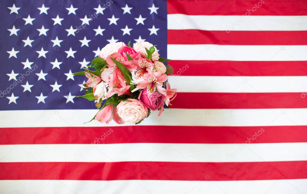 4th July Independence Day USA. American flag and bouquet of flowers for Memorial day. Memory Day concept. Federal holiday in the United States.