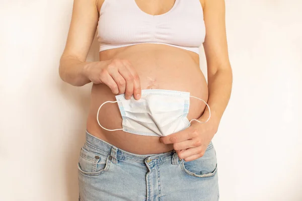 Vientre Embarazada Con Máscara Protectora Médica Sobre Fondo Claro Concepto — Foto de Stock