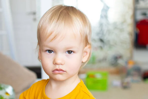 Close up portrait baby boy blond with big beautiful blue eyes on the background of the childrens room. Todler 2 year old. — Stock Photo, Image