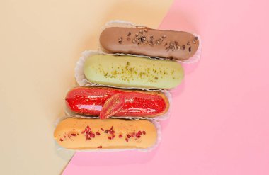 Eclairs on a minimal background. Still life hello dessert mood. Traditional French dessert with colorful icing. Concept baking, cookbook recipes, bakery banner, cafe advertisement