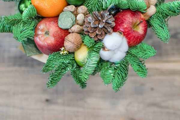 Noel ağacı dalları, elmalar, tatlılar, portakal, pamuk ve fındık..