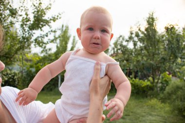 Küçük sarışın kız ve anne açık havada bahçede eğleniyorlar. Mutlu bir ailenin aktif boş vakitleri..