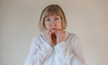 Yaşlı kadın yalnız başına depresyon stresi, kafası ellerindeyken. Baş ağrısı, migren. Sosyal belgesel kavramları