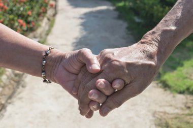 Yaşlı çift el ele tutuşuyor.