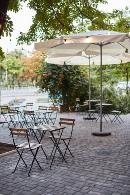 Terastaki masa ve sandalyeler bahçeli boş sokak kafesi