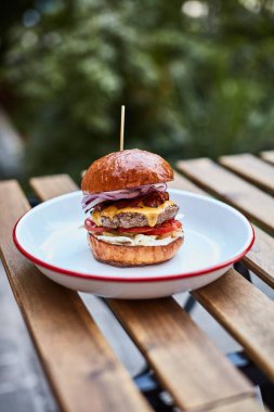 Buralardaki kafede, ahşap masada hamburger.
