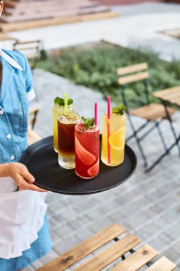 Garson terasta serinletici kokteyller hazırlıyor.