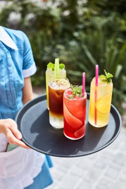 Garson terasta serinletici kokteyller hazırlıyor.